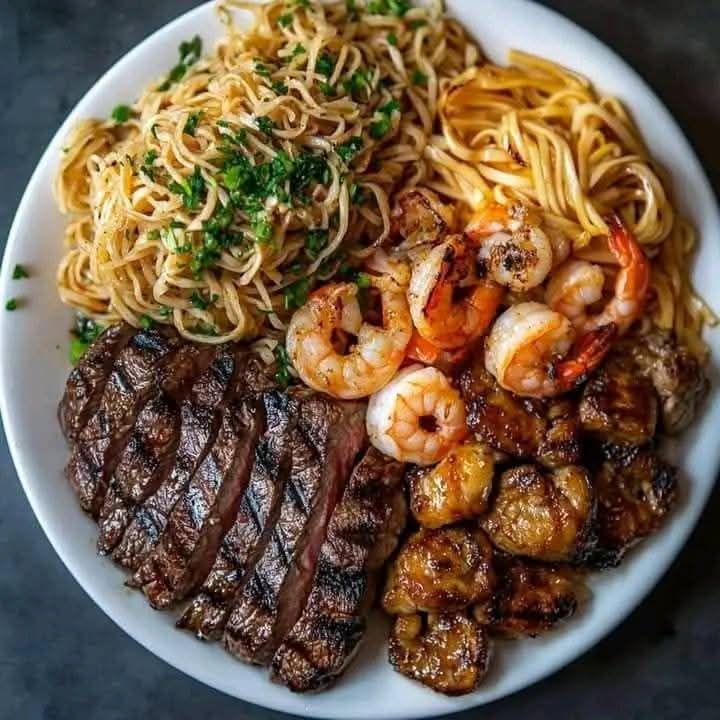 Delightful surf and turf plate with steak, shrimp, and pasta :